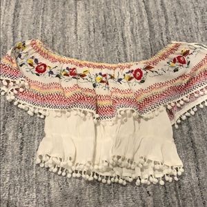 Off the shoulder ruffled top with pom poms.